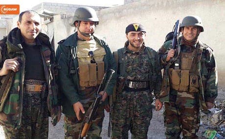 Peshmerga soldiers and YPG fighters pose for a photo in Kobane.