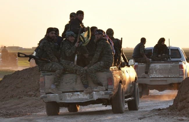 People's Protection Units (YPG) fighters drive at sunset on the outskirts of Tal Hamis, southeast of the city of Qameshli, on February 26, 2015, after they retook parts of the town following six days of clashes with ISIS jihadis in Syria's Hassakeh province.Photo: AFP.