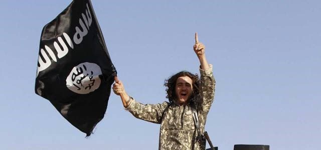 An Islamic State militant with the group's flag. Photo supplied by social media.