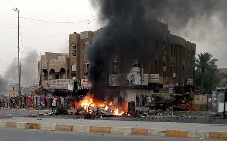 Flames and plumes of Smoke rise from a vehicle at the site of a car bomb in Baghdad. Photo: AFP