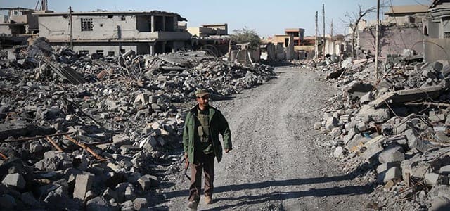 A Peshmerga walks through the damaged buildings in Shingal, Photo by Sartip Othman (Rudaw)