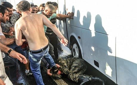 A Turkish soldier who participated in the attempted coup is kicked and beaten by people on Isbanbul’s Bosporus Bridge. Photo: Selcuk Samiloglu/AP