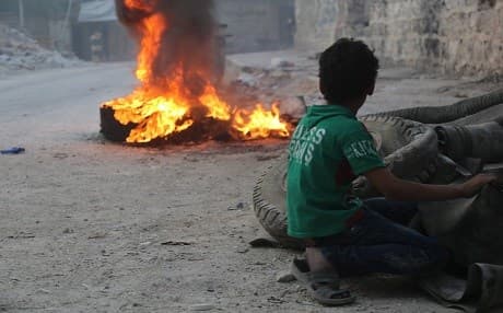 Children in Aleppo set fire to tires to block government and Russian airstrikes. Photo: @995Khaled/Syria Civil Defense