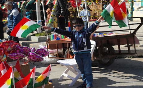 A Kurdish boy waves the flag of Kurdistan at the Sulaimani Newroz festival, 2014. Photo by Judit Neurink