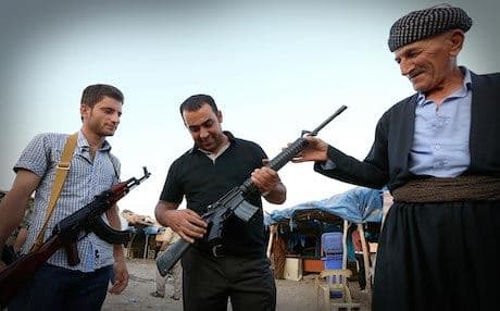 Kurdish men inspect an American M16 rifle in the Erbil gun market. Photo: AFP