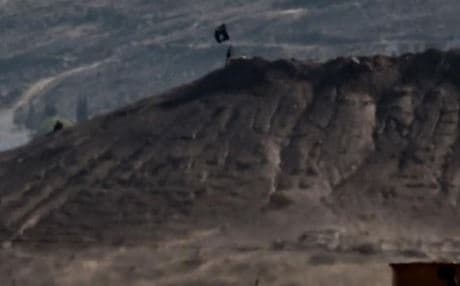 An ISIS flag seen on a hill overlooking the town of Kobane as fighters take high ground. Photo: AFP.