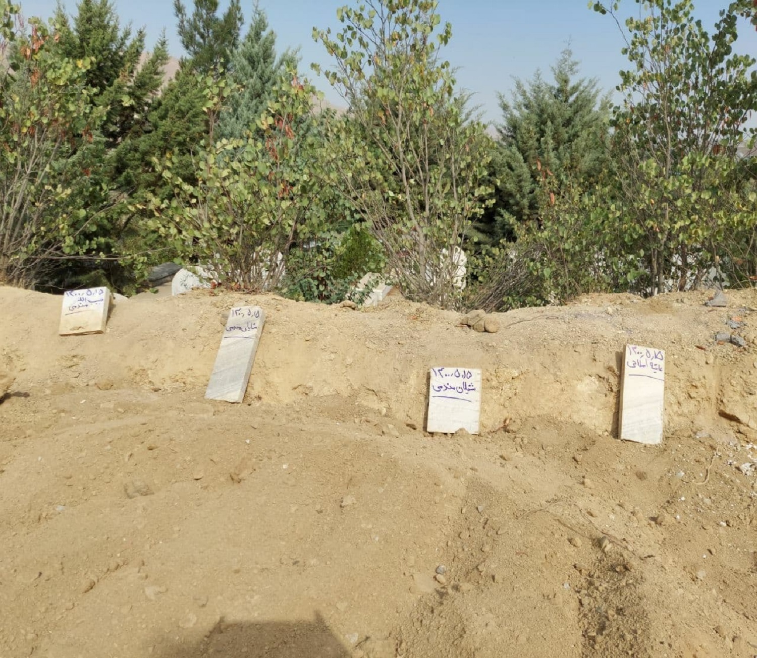 From right to left: the graves of Aisha Aslani, Shilan Mandumi, Shayan Mandumi, Habibullah Mandumi at the Bahashti Mohammedi cemetery in Sanandaj, Kurdistan Province, Iran. August 7, 2021. Photo: Jabar Dastbaz/Rudaw English