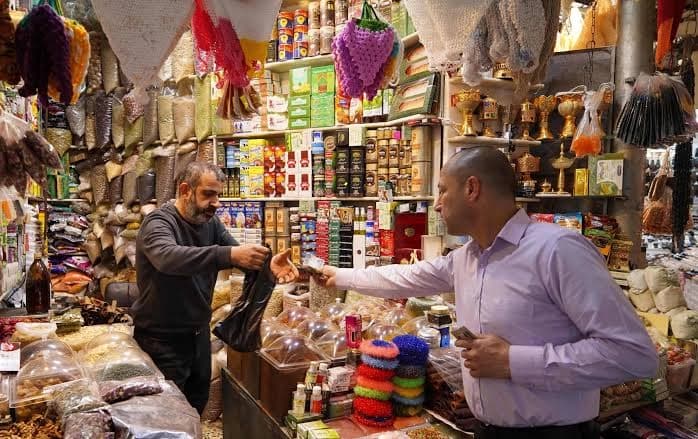 هاونیشتمانییەک لەکاتی کڕینی پێداویستییەکانی لە بازاڕی دهۆک. وێنە: AFP/ئەرشیڤ