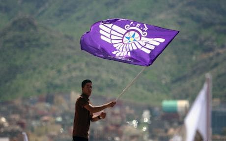 An Assyrian Christian man waves a flag bearing the symbol representing the Assyrian homeland as he celebrates their New Year (Aketo) in the city of Dohuk, April 1, 2013. Photo: AFP