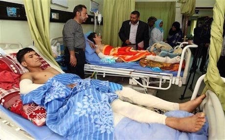 AP Photo: Volunteer fighters wounded during clashes with ISIS in Baghdad.