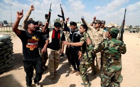 Iraqi fighters chant slogans against extremists at the front line during a battle against ISIS in Tikrit. AP photo