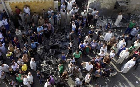 People gather at the scene of a car bomb attack in Baghdad. AP photo