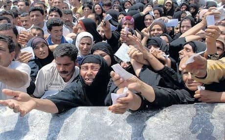 Iraqi families gathered outside a food center. AP file photo 