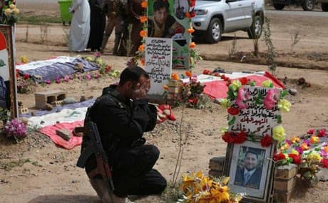 A Sunni fighter from the al-Jabouri tribe weeps in front of the grave of his relative killed in a battle with ISIS. AP file Photo 