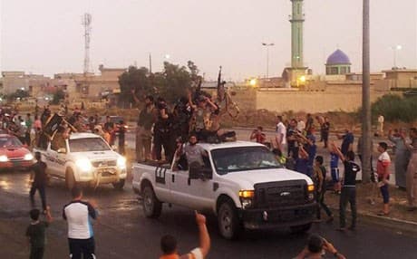 ISIS fighters parade through the streets of Mosul, Iraq, on June 25. AP file photo 