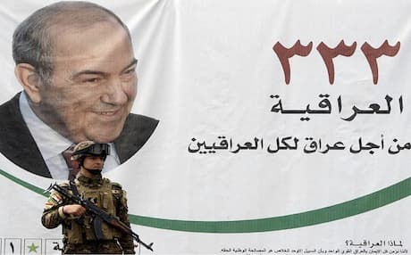 An Iraqi soldier guarding a location of al-Iriqayah bloc stands in front of a portrait of former Iraqi premier Iyad Allawi in Baghdad on April 17, 2010. Photo: AFP