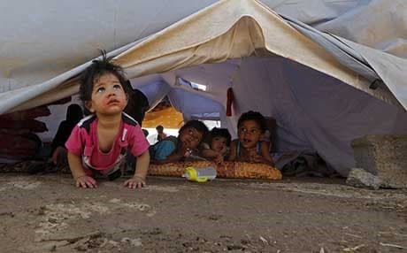 Displaced children sit inside a UNHCR tent at a temporary camp in Kurdistan Region. AFP Photo