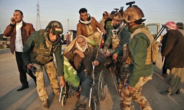 Kurdish Peshmerga help move an elderly Yazidi after around 200 captives were released by ISIS militants. AP file photo. 