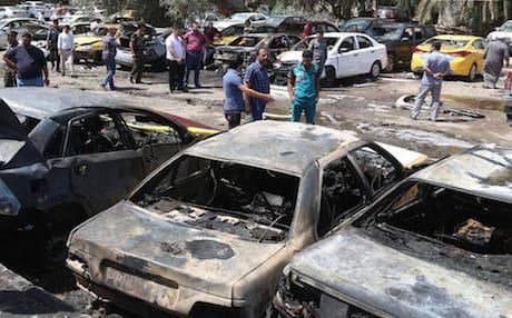 AP File Photo: People and security forces gather at the scene of a car bomb explosion in a parking lot outside Yarmouk hospital in western Baghdad, Iraq, Tuesday, April 14, 2015.