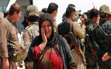 AP File Photo: A Yazidi woman, released by ISIS, reacts upon her arrival in the village of al-Humeira, 35 kms southwest of Kirkuk, on April 8, 2015