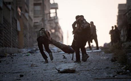 Rebels help a severely wounded colleague after being shot by a Syrian Army sniper in Aleppo. AP photo. 
