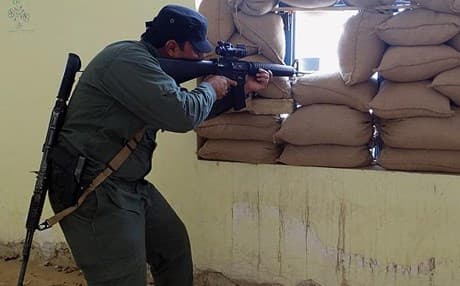 An Iraqi Sunni tribal fighter aims his gun to protect the headquarters from an attack by ISIS in Ramadi. AP photo