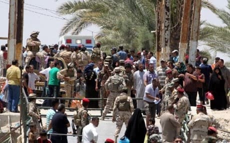 Iraqi security forces stand guard as residents from the city of Ramadi fled their homes to escape an advance by ISIS. AFP photo