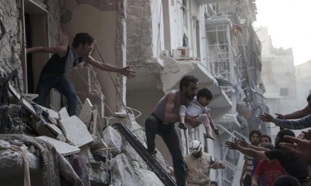A man evacuates a child from a building following a reported barrel-bomb attack by Syrian government forces in the Shaar neighbourhood of the northern Syrian city of Aleppo.Photo: AFP. 