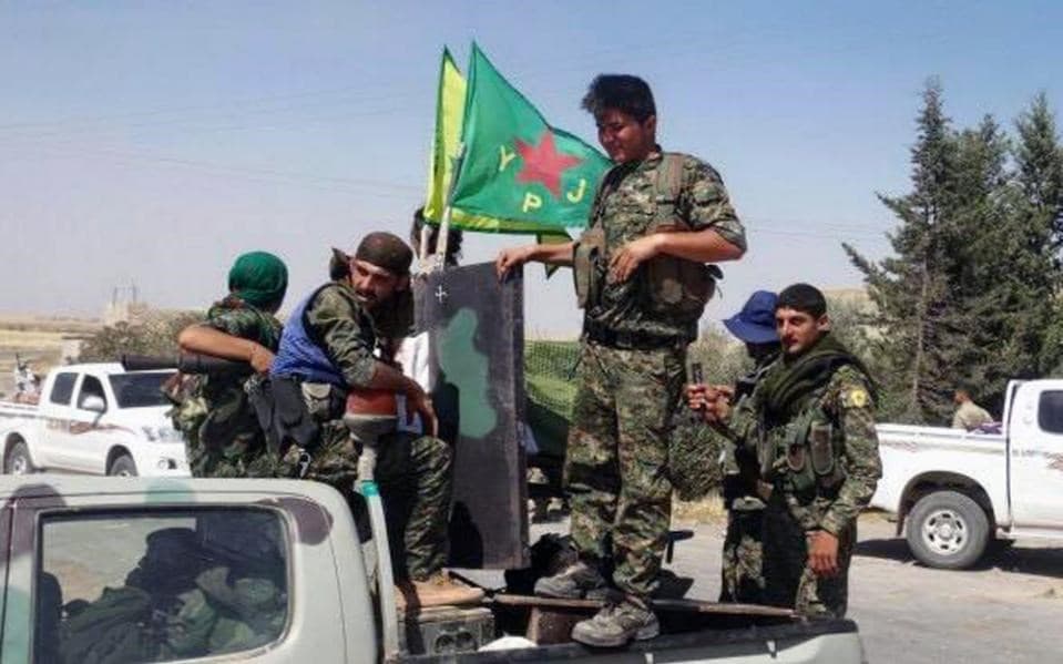  In this photo provided by the Kurdish fighters of the People's Protection Units (YPG), which has been authenticated based on its contents and other AP reporting, Kurdish fighters of the YPG, sit on their pickup in the town of Ein Eissa, north of Raqqa city, Syria, Tuesday, June 23, 2015.AP file photo.