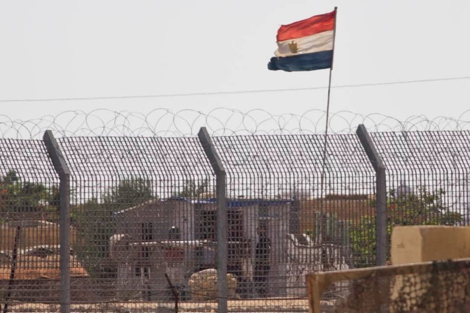 An Egyptian military officer watches at a post in Egypt's northern Sinai Peninsula, as seen from the Israel-Egypt border, in Kerem Shalom village, southern Israel, Wednesday, July 1, 2015
