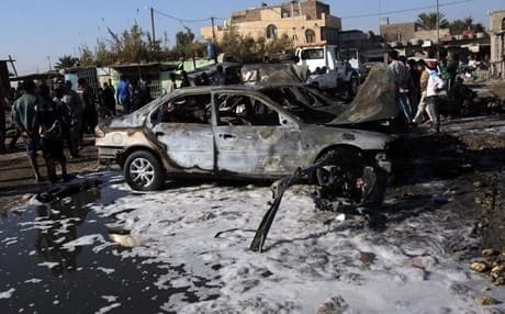 People gather around the site of a car bomb in Baghdad. AP file photo