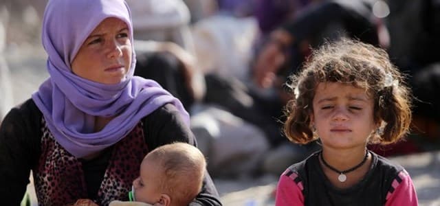 A Yazidi Iraqi woman sits with her children at the Bajid Kandala camp near the Tigris River, in Kurdistan’s western Dohuk province. AFP file photo