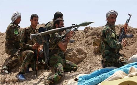 Shia fighters from the popular committees fire towards ISIS positions in Anbar province. Photo : AFP