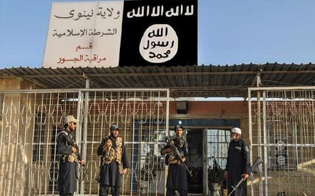 ISIS militants in front of a police station in Nineveh province, Iraq. Photo :AP