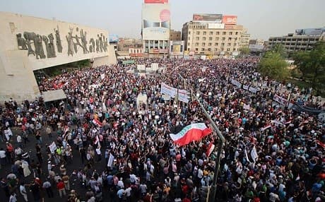 Iraqis demonstrators gathered in Tahrir Square wave their national flag and chant against corruption and poor services in Baghdad. Photo: AFP  