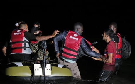 Migrants from the coastal town of Bodrum in Turkey remove a man from their boat, before heading to the Greek island of Kos in mid-August. Scuffles on the overloaded migrant boats are common. AP file photo.
