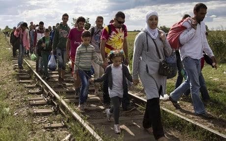 Migrants cross into Hungary, bypassing authorities as they walk over railroad tracks at the Serbian border on Monday. Photo: AFP/Getty Images.