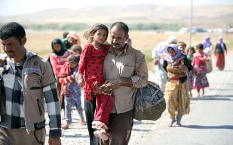 A displaced Iraqi man carries his daughter. Photo: AFP