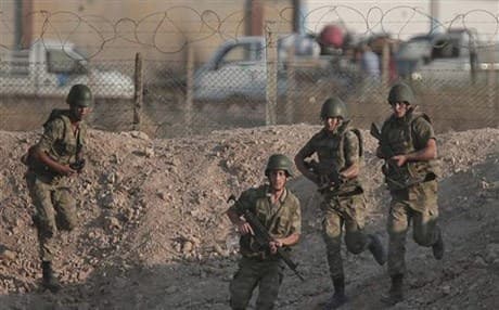 From the Turkish side of the border between Turkey and Syria, Turkish soldiers run to their new positions next to the border fence in Akcakale, southeastern Turkey. AP photo.