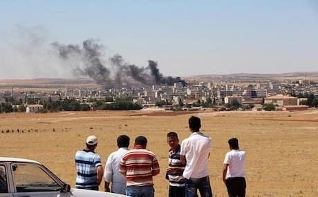 Residents of Kobani watching smoke rise from their city during street battles between the Kurdish YPG forces and ISIS militants, 2014. Photo: Rudaw