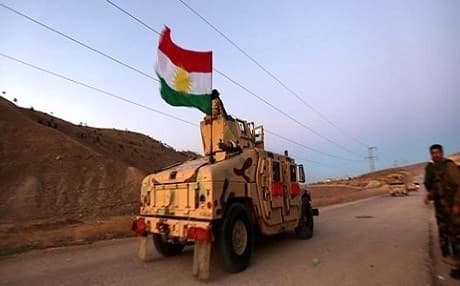 A Kurdish flag waves out of a Peshmerga armored vehicle during Thursday's Shingal offensive. Rudaw photo.