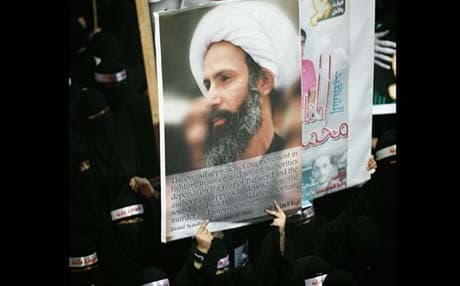 A protester holds up a poster of Sheikh Nimr al-Nimr during the funeral of three Shias killed in the aftermath of Nimr’s arrest. Photograph: AP