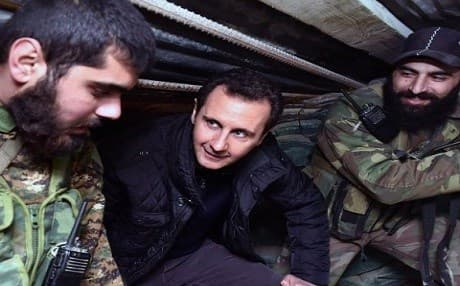 Syrian President Bashar Assad, center, speaks with Syrian troops during his visit to the front line in the eastern Damascus district of Jobar, Syria.AP File Photo.