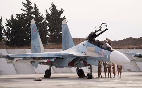 Russian air force personnel stand near a Russian war plane at Hemeimeem airbase, Syria. AP File Photo. 