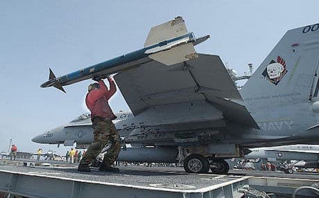 A US Navy personnel arms a fighter jet with a Sidewinder missile. Photo: US military