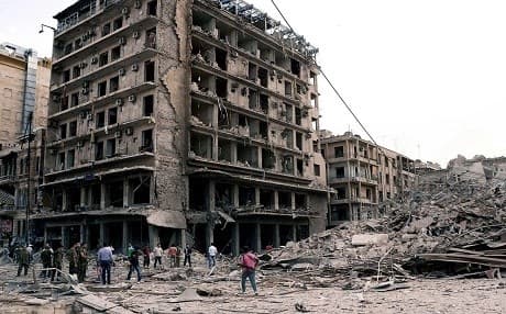 Syrian civilians and gunmen gather in front of destroyed buildings damaged by war in Syrian Aleppo city. Photo: AP 