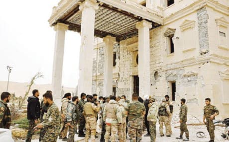 Syrian soldiers outside of damaged palace in Palmyra / AP Photo.