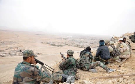 Syrian soldiers take up positions during fighting against ISIS militants in Palmyra. Photo: AP 