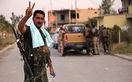 A Kurdish peshmerga fighter flashes the sign for victory in Tel Skof. AFP file photo. 