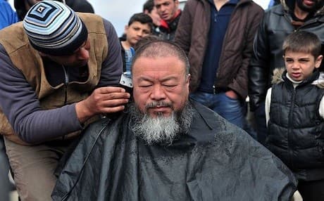 Artist and refugee advocate Ai Weiwei gets a haircut in a camp on the Greece-Macedonia border on March 17, 2016. Photo: Sakis Mitrolidis/AFP